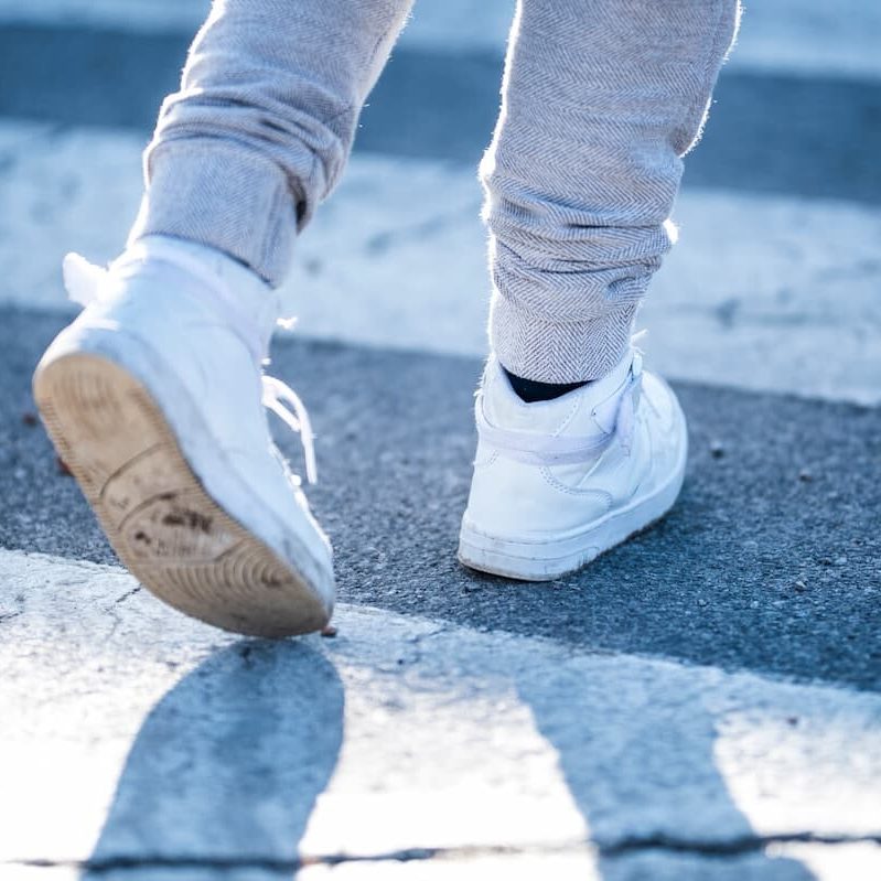 the shoes of a child crossing the road